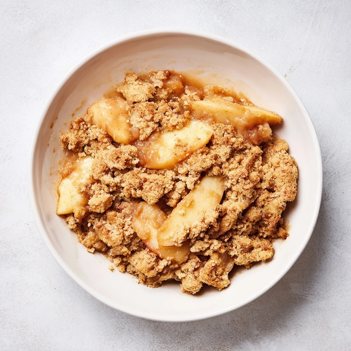 Warm Rustic Apple and Cinnamon Crumble bubbling, a cozy dessert for sharing with vanilla ice cream.