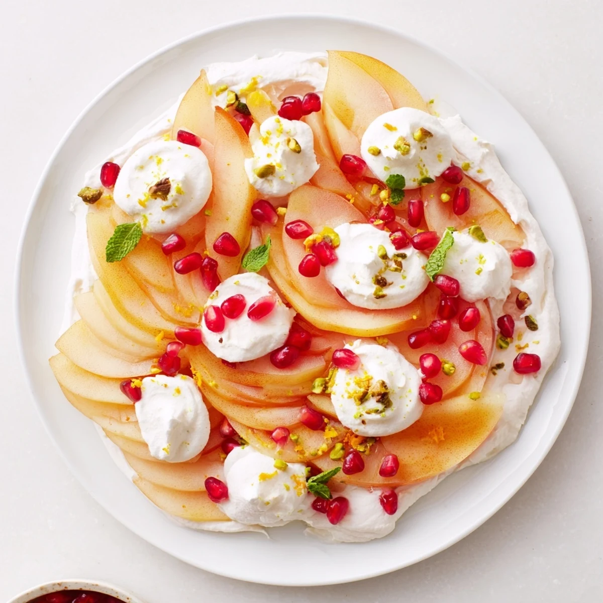This plated Winter Fruit Snowscape, featuring persimmons, pears, and cream, presents a delightful, light dessert.