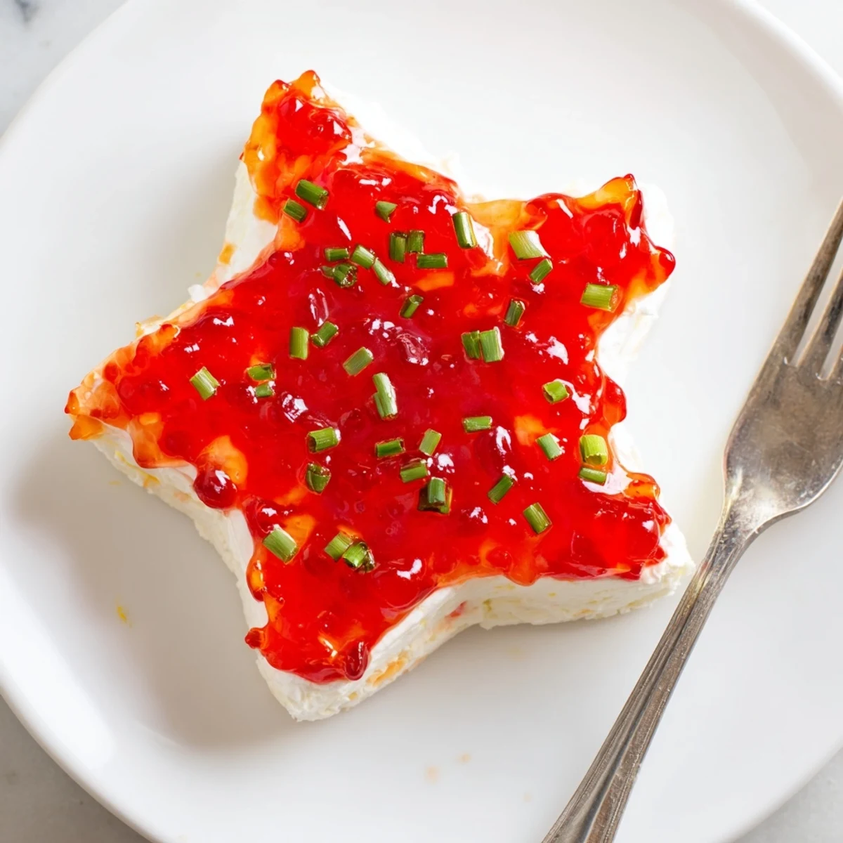 Cream Cheese and Pepper Jelly Star Appears as a festive, star-shaped appetizer with vibrant red pepper jelly.