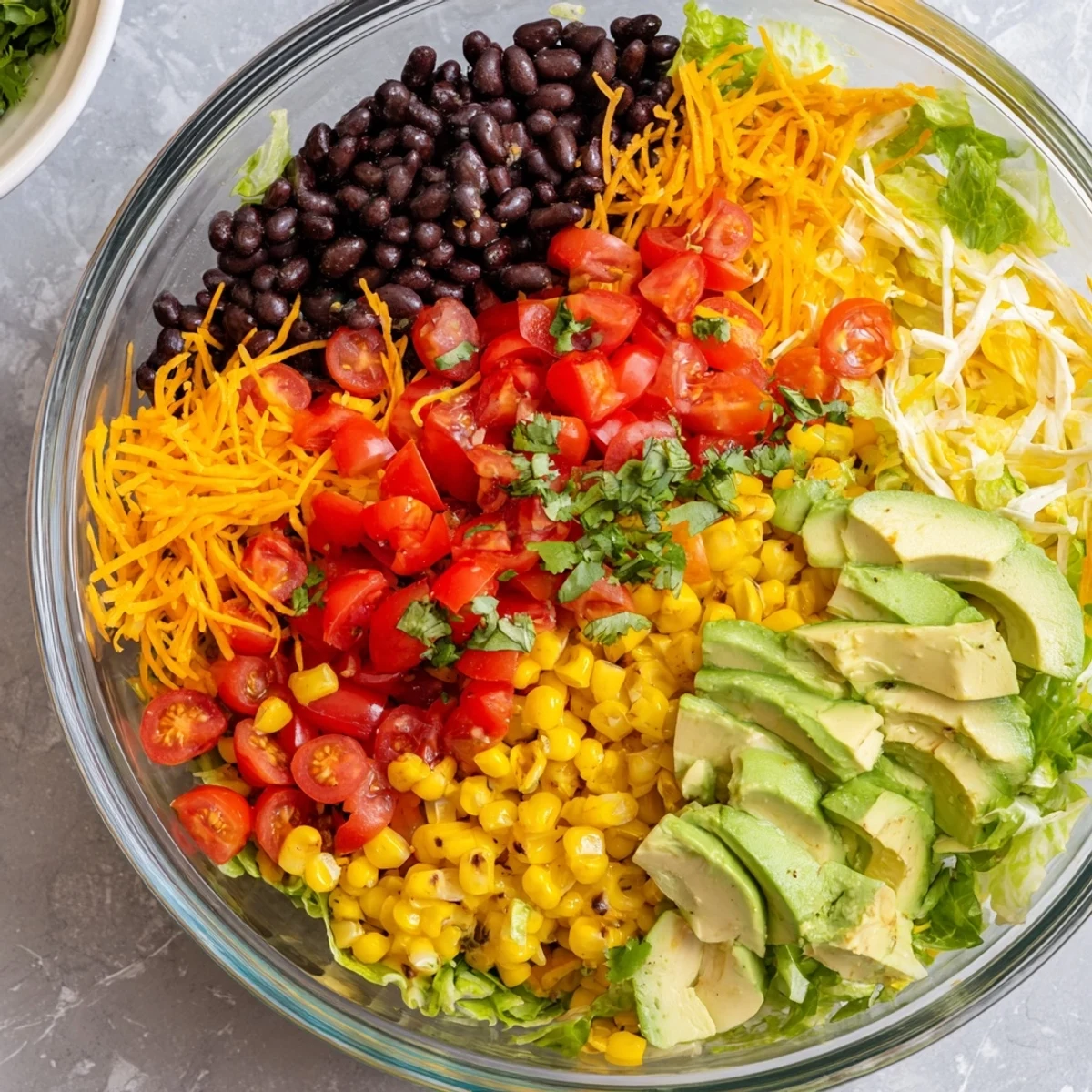 See the beautiful colors of a Southwest Sunset Palette salad: black beans, peppers, and cheese, ready to serve.