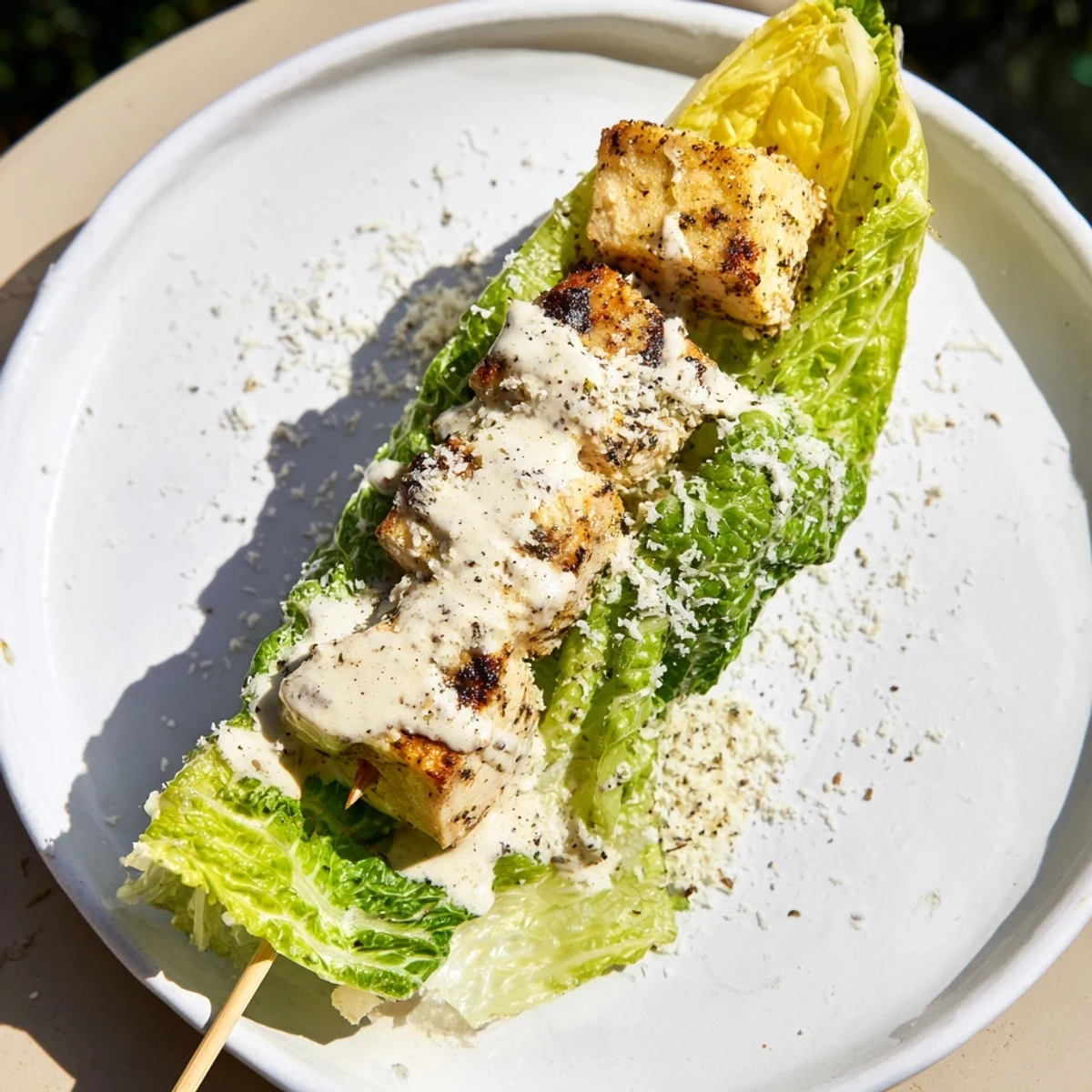 Grilled Chicken Caesar Salad Skewers: a close-up shows skewers with grilled chicken, romaine, and creamy Caesar dressing.