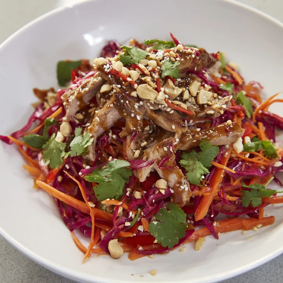 A zesty Ginger-Miso dressing coats this refreshing Carrot Ribbon and Chicken Slaw, ready to serve!