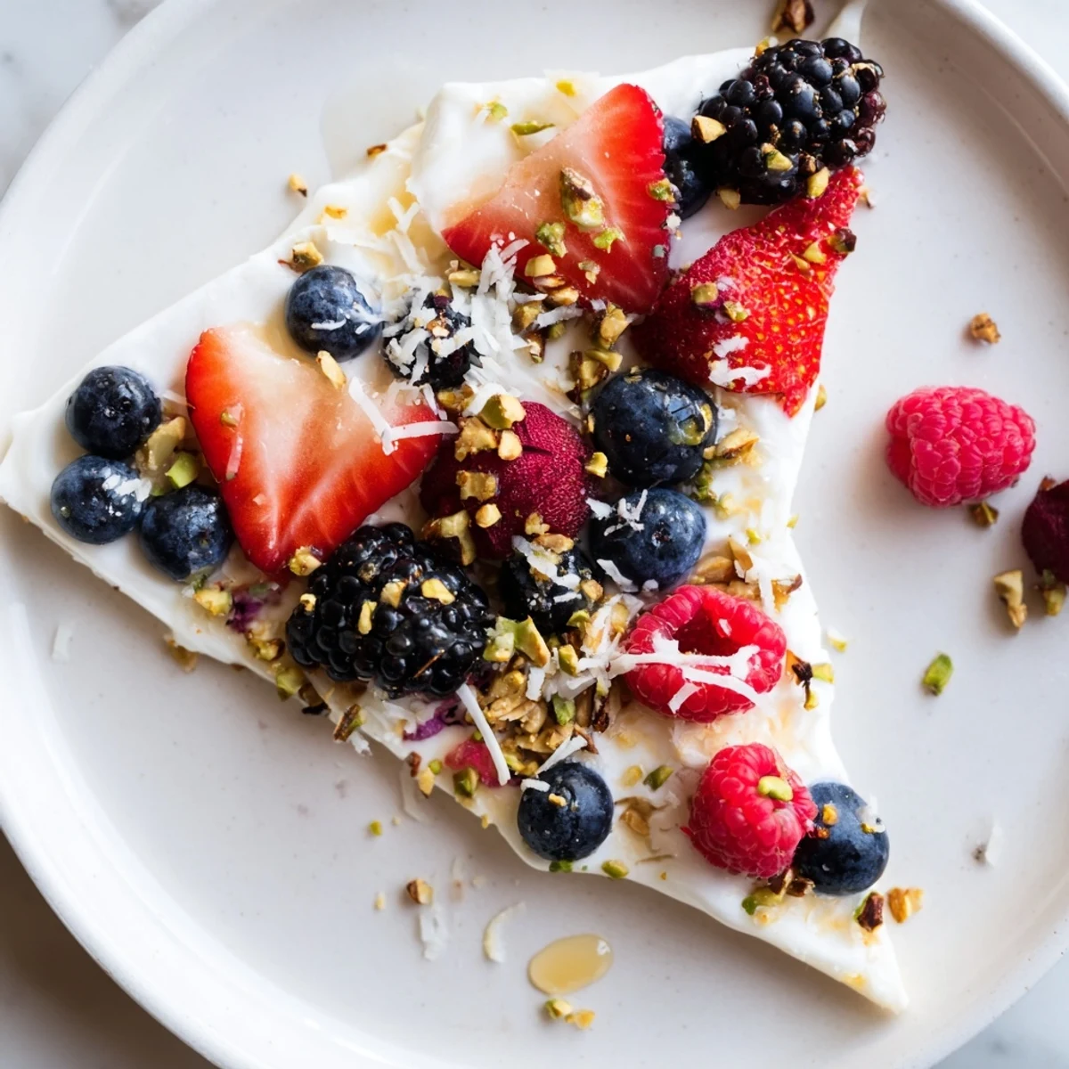 A close-up of Berry Yogurt Bark with juicy berries and crunchy toppings offers great texture.