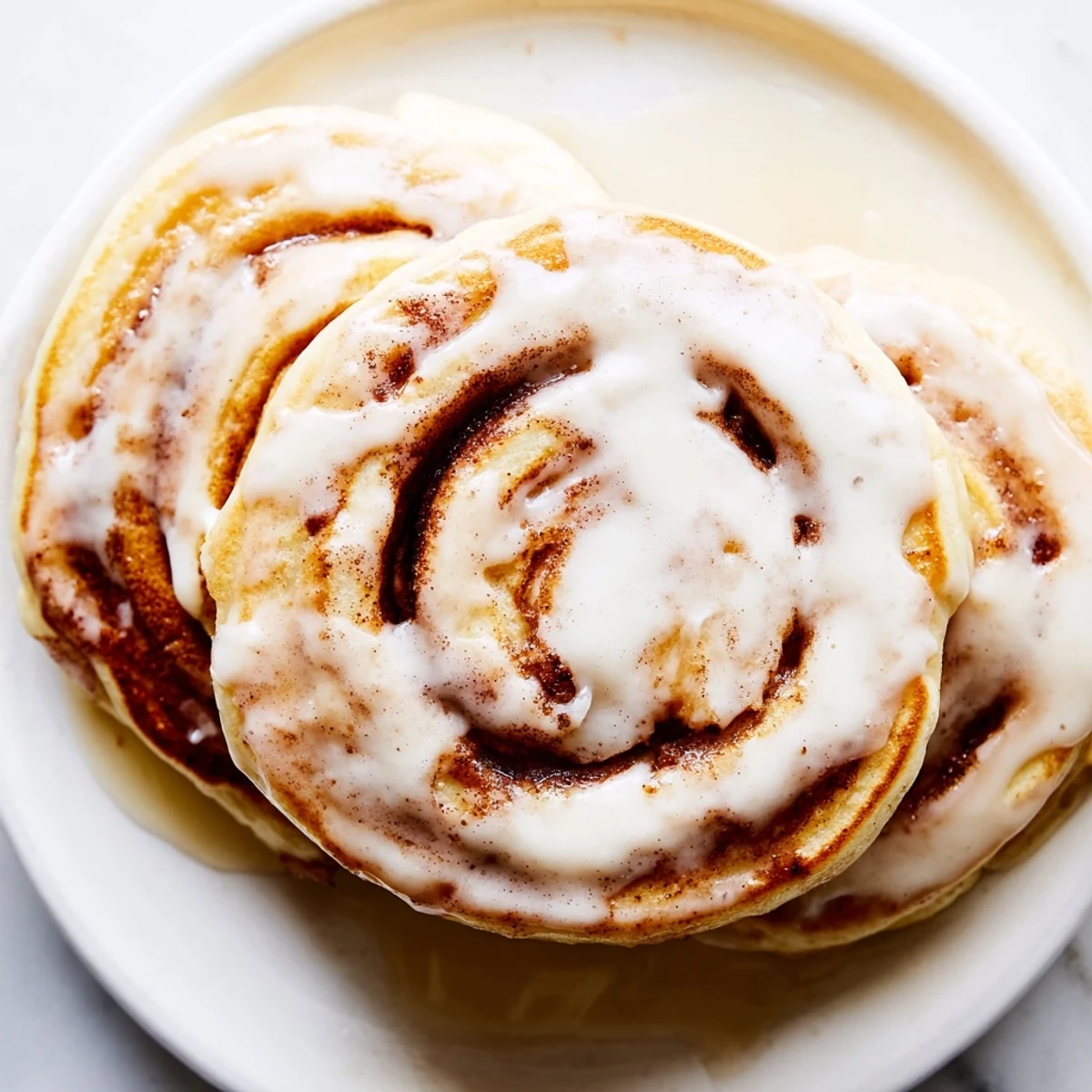 Fluffy cinnamon roll pancakes with a swirl of cinnamon, a decadent breakfast food, taste amazing.