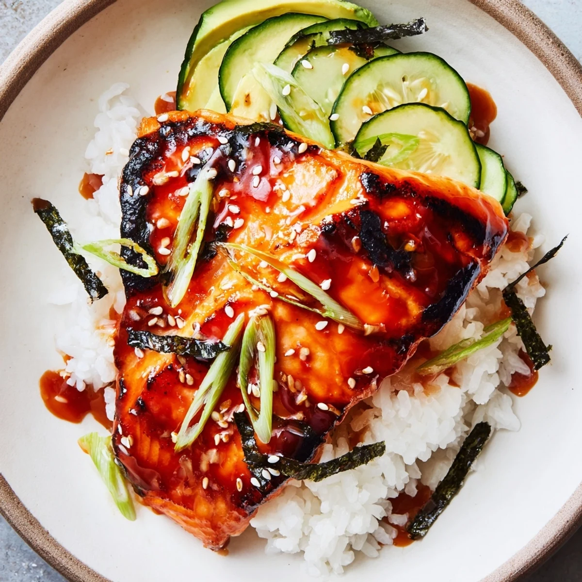 Delectable Emily Mariko-Inspired Salmon Bowl with vibrant orange glaze, served with fluffy rice and fresh toppings.