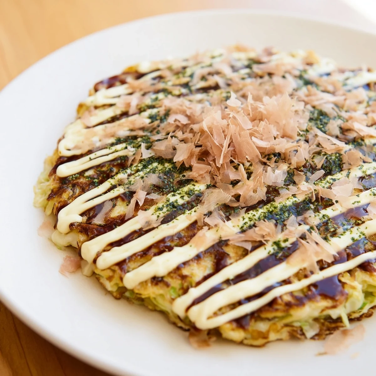 Steaming Japanese Okonomiyaki pancakes, savory and loaded with cabbage and shrimp, ready to eat.