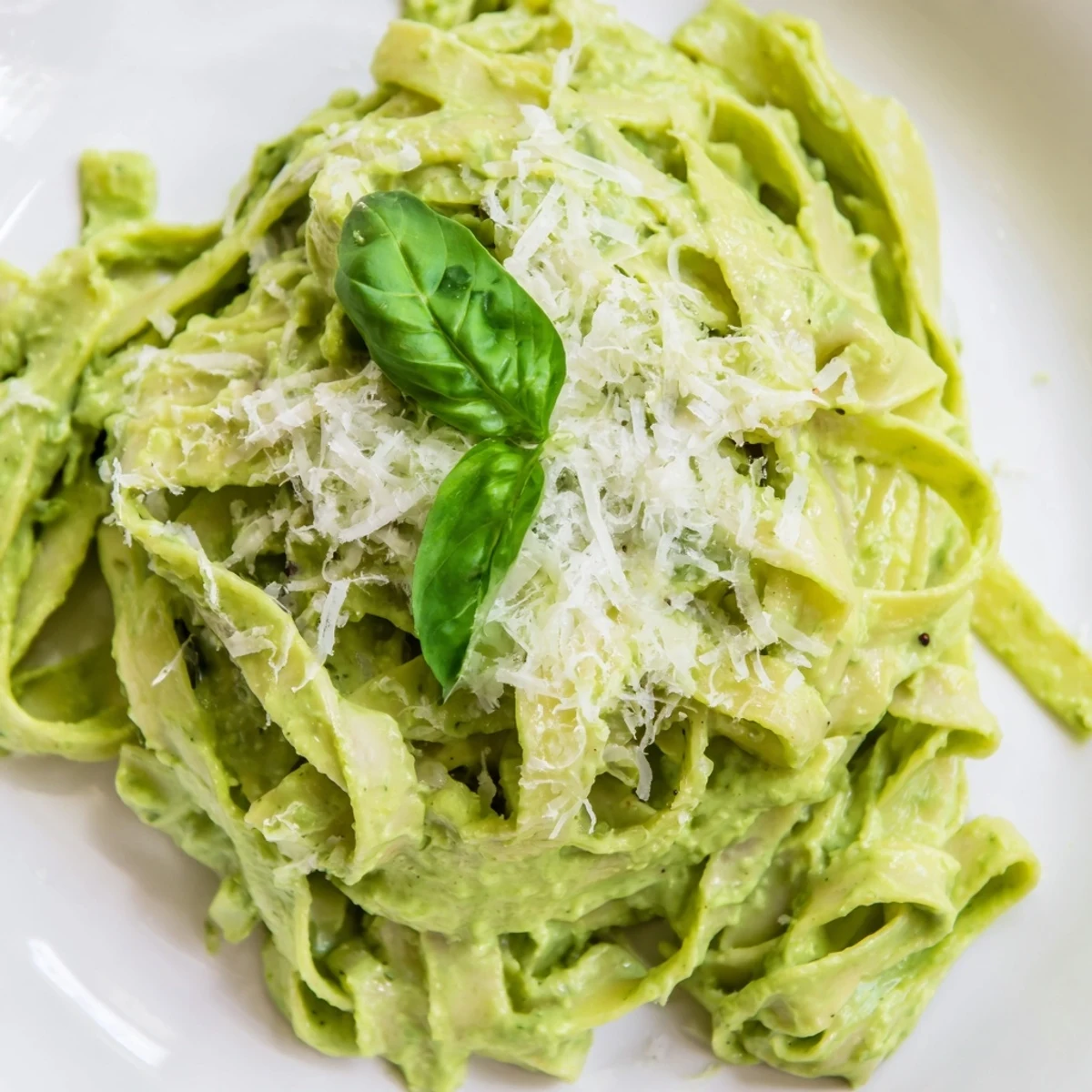Green pea Alfredo in a skillet, featuring tender pasta swirled in a bright, cheesy sauce, ready to be garnished and enjoyed.