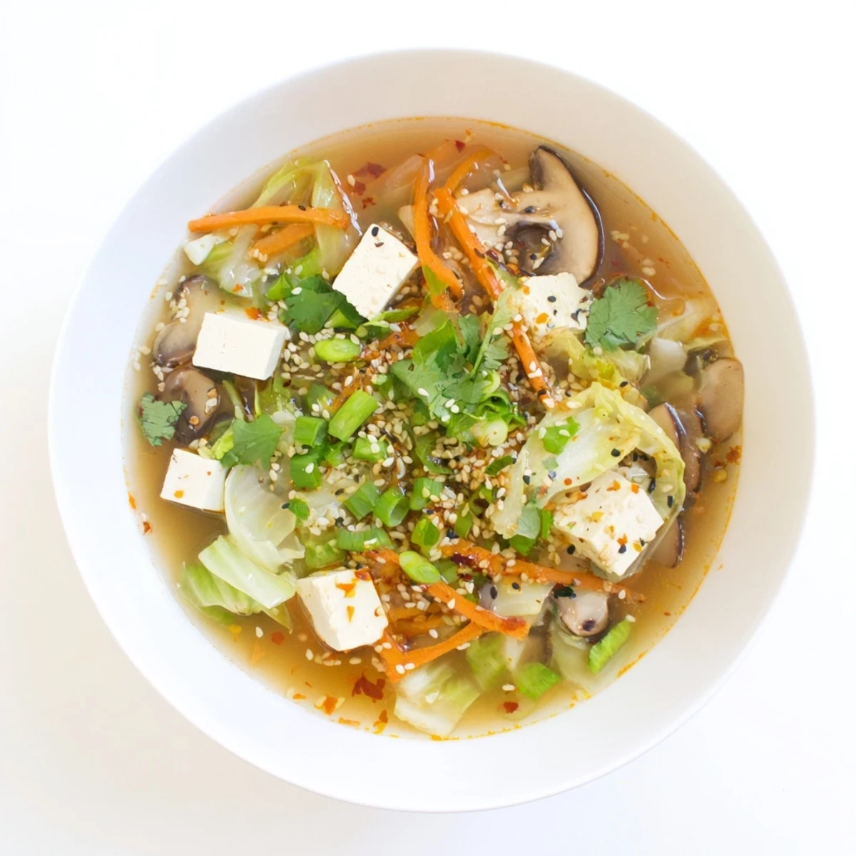 A steaming bowl of Ginger-Miso Winter Soup, featuring tender napa cabbage and shiitake mushrooms in a savory broth.