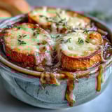 A rich bowl of Dutch Oven French Onion Soup features bubbling cheese, savory broth, and crispy bread under a home oven broiler.