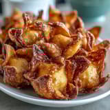 Golden dandelion fritters with crispy batter and herb dipping sauce on a white plate.