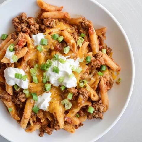 Steaming, cheesy one-pot taco pasta, a budget-friendly Tex-Mex meal, ready to enjoy.