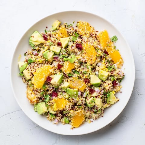 A close-up of a Fresh Citrus & Avocado Quinoa Bowl, showcasing vibrant colors and fresh herbs.