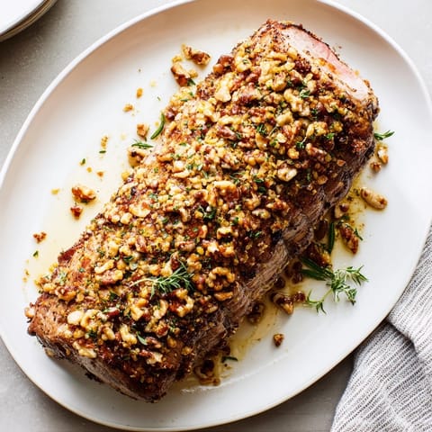 Crispy pecan crust coats this delicious Thyme and Pecan Crusted Pork Tenderloin, a flavorful American entree.