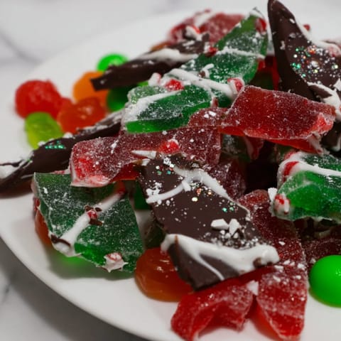 Festive Jingle Bell Rock Candy pieces shine alongside colorful chocolates, a delightful sweet holiday dessert showcase.