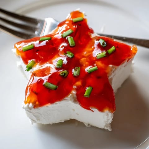A close-up of creamy Cream Cheese and Pepper Jelly Star on a platter, ready to serve with crackers.