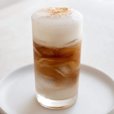 A close-up view of Iced Chai Tea with Cold Foam, highlighting the creamy foam layer on spiced chai.  