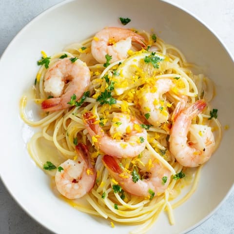 Lemon Garlic Shrimp Pasta tossed with fresh parsley and lemon wedges, ready to be enjoyed.  