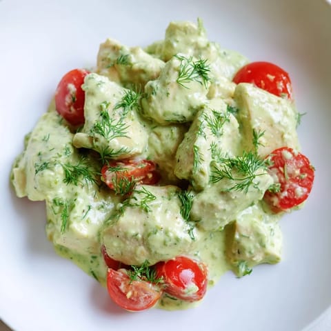 Creamy avocado ranch chicken salad with diced celery, juicy tomatoes, and herbs, ready for a light lunch or dinner table setting.