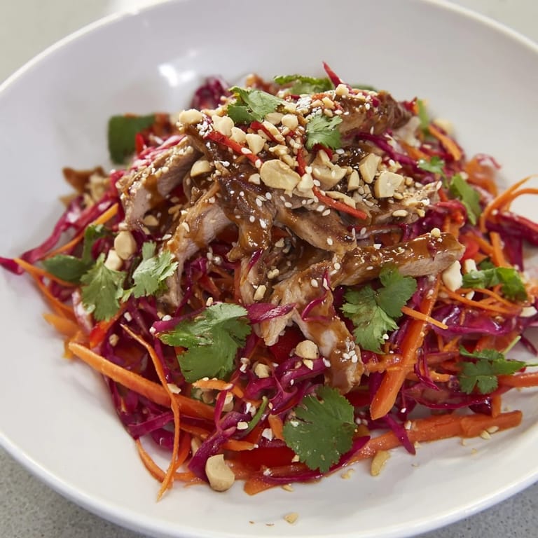 A zesty Ginger-Miso dressing coats this refreshing Carrot Ribbon and Chicken Slaw, ready to serve!