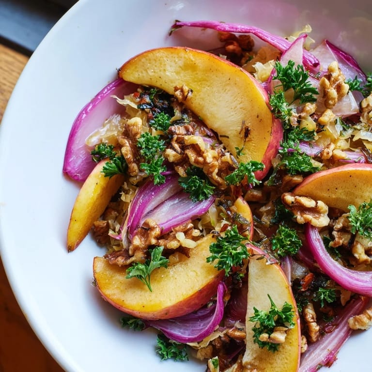 A close-up of the warm apple and sauerkraut skillet salad, showcasing caramelized apple slices mingling with probiotic sauerkraut and caraway seeds.